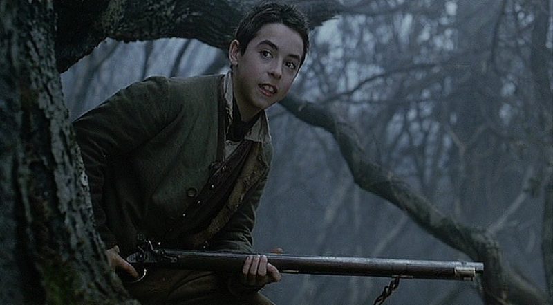 young masbath holds his rifle as he emerges from behind a tree in the haunted forest