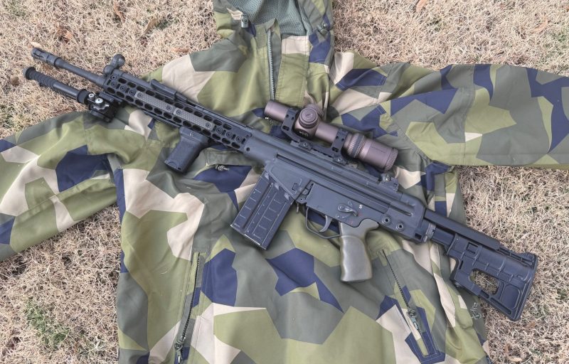 The rifle build featured here is shown on top of an M90 camouflage windbreaker.
