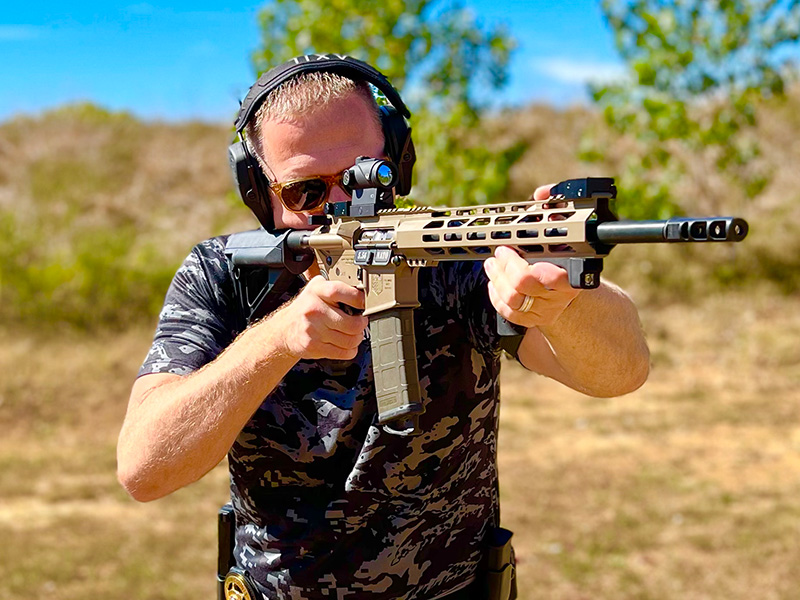 What is a forced reset trigger? A man demonstrating how to hold an AR-15 DB 5.56 Range with such a trigger installed.