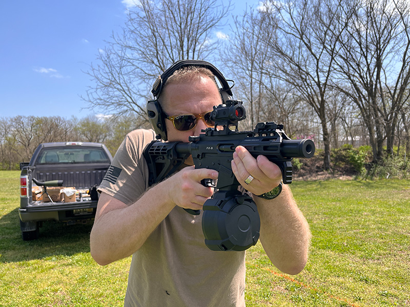 A man demonstrating how to carry an AR-15 Range Drum.