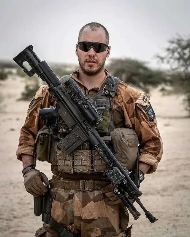 Swedish soldier shown with a military AK4D complete with the front sight post cut off.