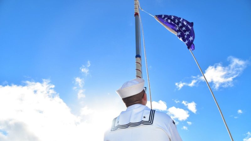 The blue US Navy Union Jack being raised above the USS Chung-Hoon (DDG 93). 